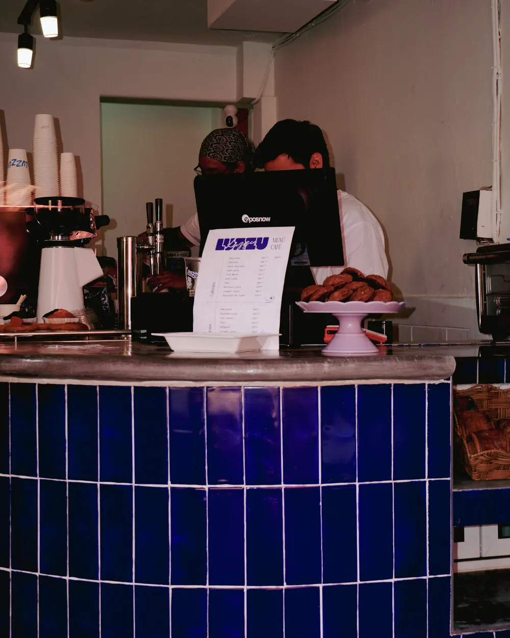 La barra de azulejo azul de LUZZU Café con la máquina de espresso